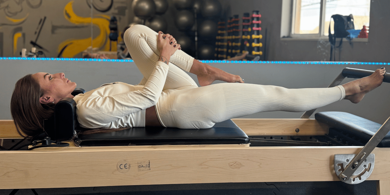 Tatiana w leżeniu na Pilates Reformer – rozluźnienie biodra i wydłużenie nogi, Silver Gym Bełchatów
